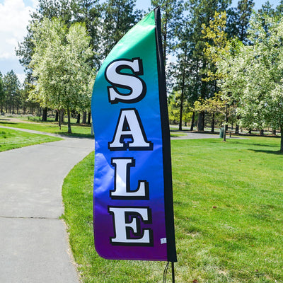 4-foot Heavy Duty Sale Gradient Double-Sided Feather Banner with vibrant rainbow gradient, displayed outdoors at a storefront to attract customers.