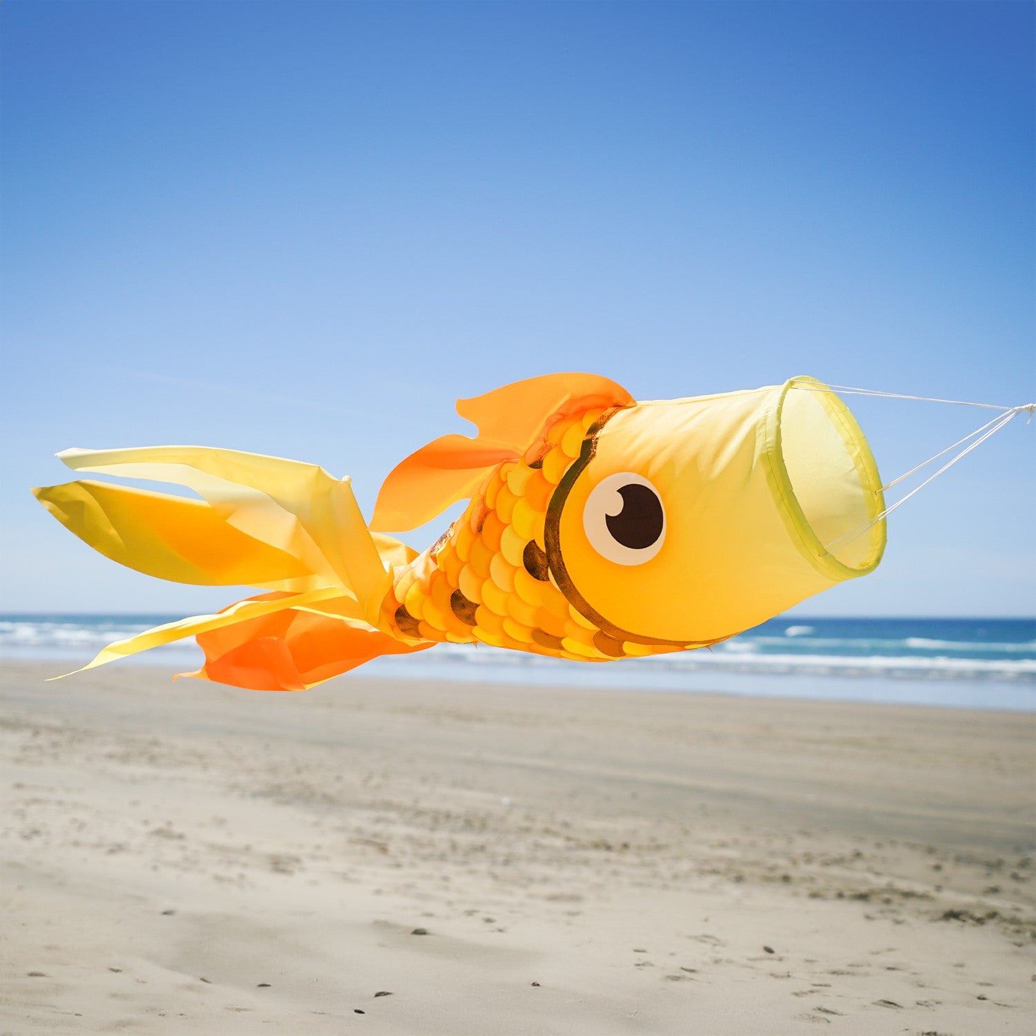 40-inch Gold Shimmer Damsel Fish Windsock with shiny scales and colorful tail, gracefully swaying in the breeze in a garden setting.