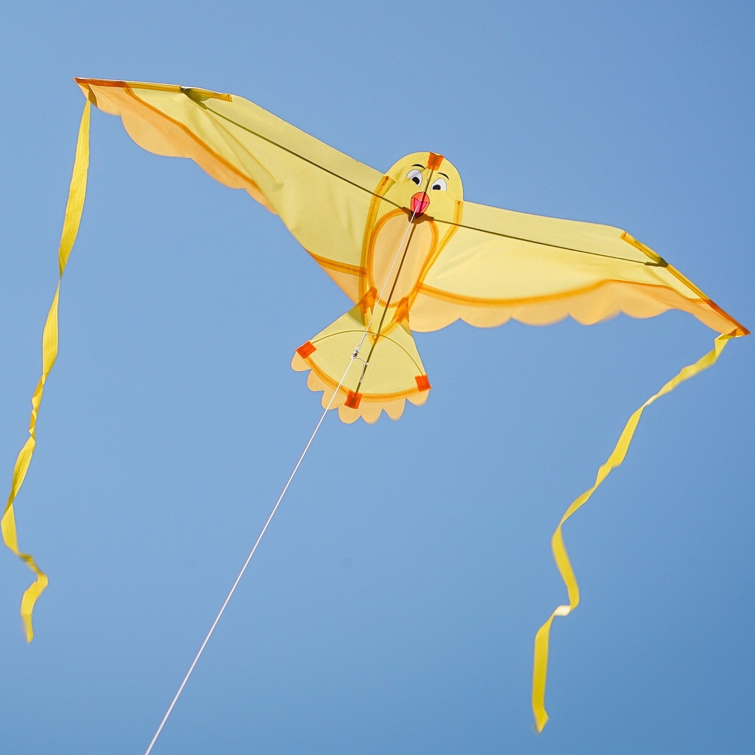 40-inch Yellow Bitty Bird Kite soaring in the sky with color-coordinated streamer tails and a cheerful bird design.