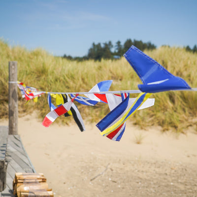 40 Piece Maritime Signal Flags on String decorated across a wooden terrace, featuring various colors and nautical designs that represent maritime communication.