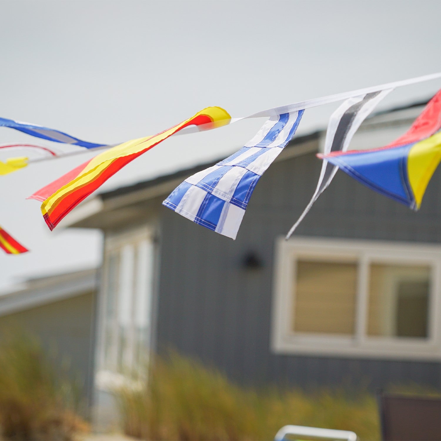 40 Piece Maritime Signal Flags on String decorated across a wooden terrace, featuring various colors and nautical designs that represent maritime communication.