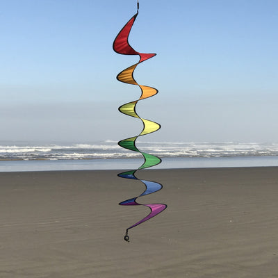 Vibrant 48-inch Rainbow Curlie fluttering in the wind, showcasing bold colors and dynamic movement against a clear sky.
