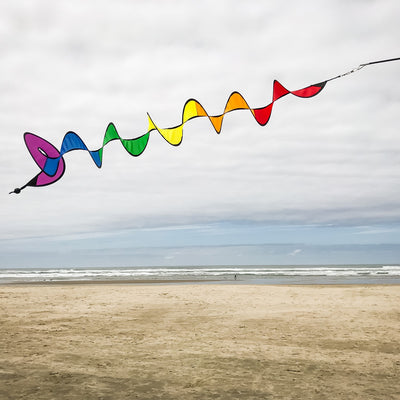 Vibrant 48-inch Rainbow Curlie fluttering in the wind, showcasing bold colors and dynamic movement against a clear sky.