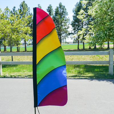 4' Heavy Duty Rainbow Double Sided Feather Banner displaying a vibrant rainbow gradient design outdoors, perfect for business promotions.