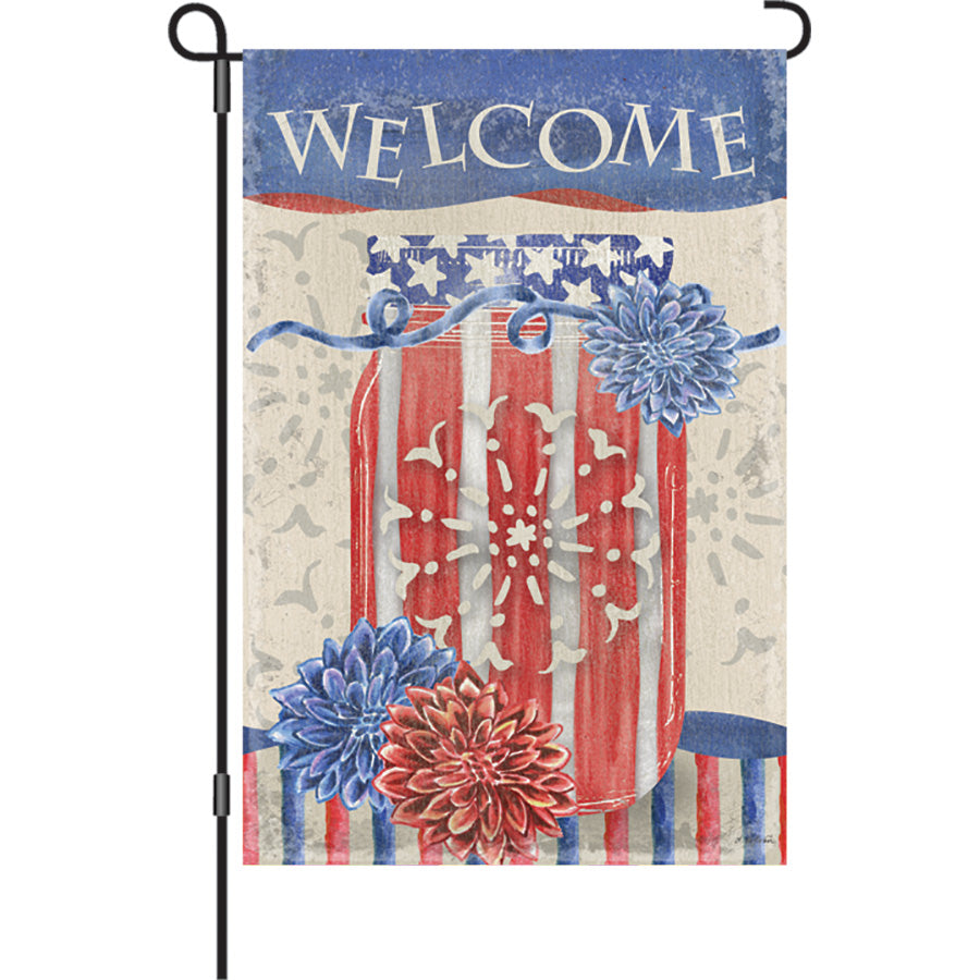 12 in. Flag - 4th of July Jar features a vibrant double-sided design displayed in a garden setting, adding patriotic flair to outdoor decor.