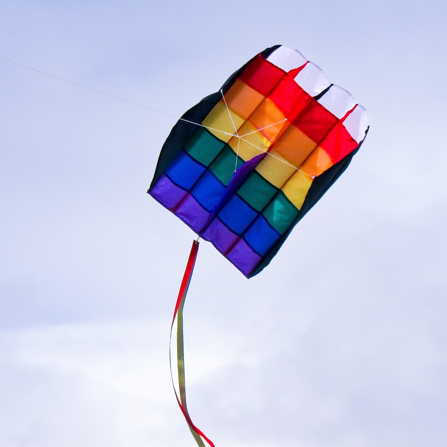 5.0 Rainbow Stripes Air Foil kite soaring in a clear blue sky, showcasing colorful appliques and attached tails in flight.