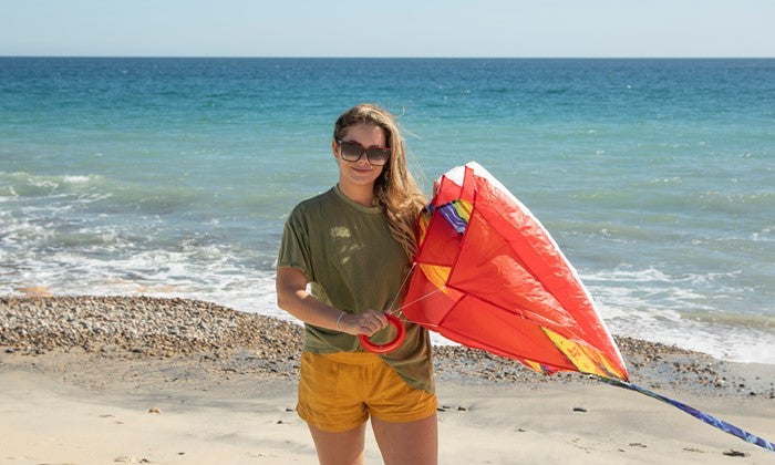 5.0 Tie Dye Red Air Foil Kite soaring in a bright blue sky, showcasing its vibrant colors and aerodynamic structure.