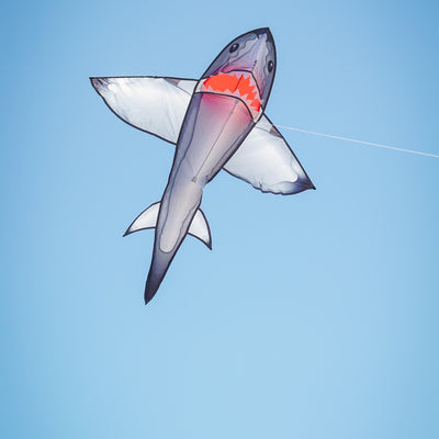 5' Realistic Shark Kite gliding through the sky, showcasing its 3D appearance and toothy grin, perfect for outdoor activities.