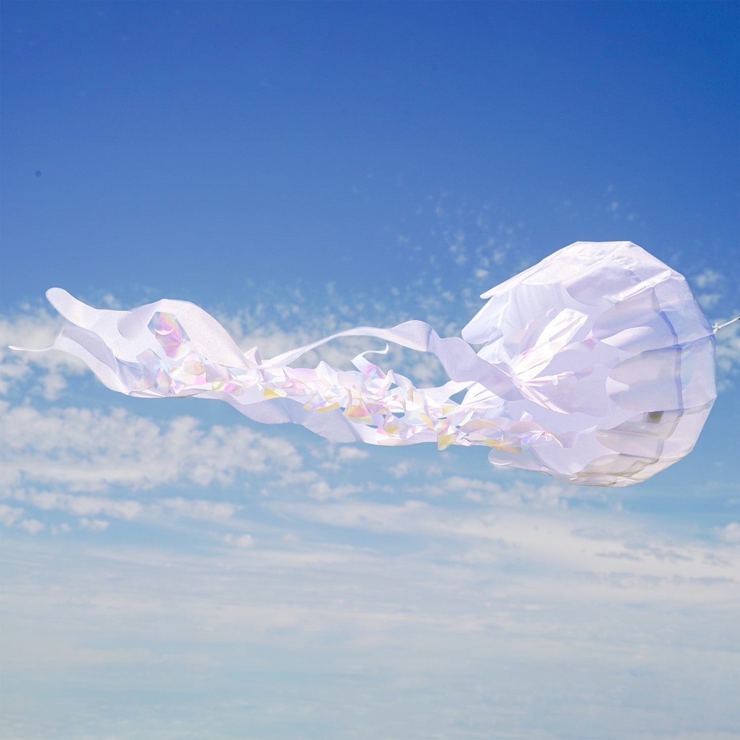 50-inch White Iridescent Jellyfish 3D Windsock with flowing tentacles, displayed outdoors, capturing sunlight with stunning iridescent colors.