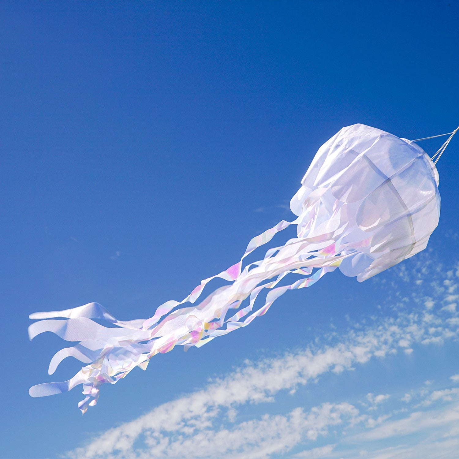 50-inch White Iridescent Jellyfish 3D Windsock with flowing tentacles, displayed outdoors, capturing sunlight with stunning iridescent colors.