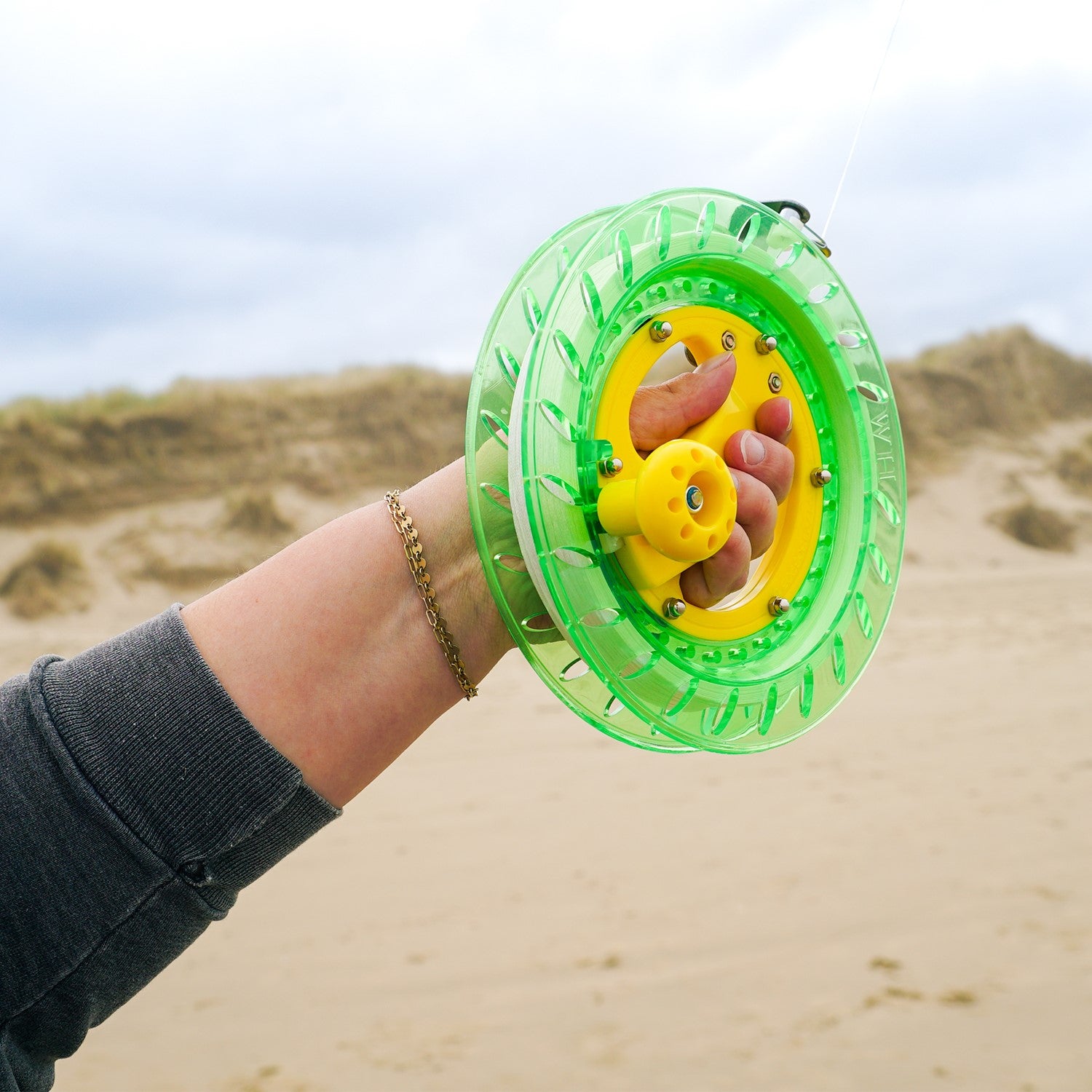 50 LB x 640' green kite reel featuring a sturdy plastic design and easy-lock mechanism, alongside a kite line smoothly wound for flying.