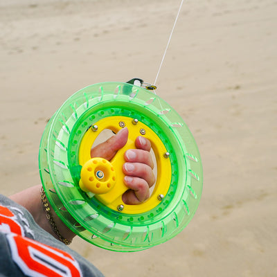 50 LB x 640' green kite reel featuring a sturdy plastic design and easy-lock mechanism, alongside a kite line smoothly wound for flying.