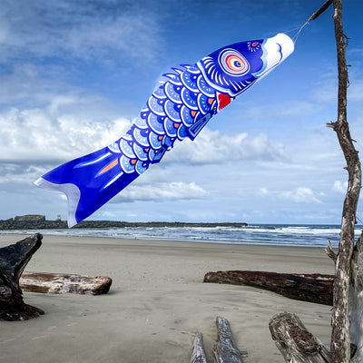 60-inch Blue Koi windsock hangs gracefully outdoors, featuring colorful koi fish design, enhancing garden decor with vivid hues.