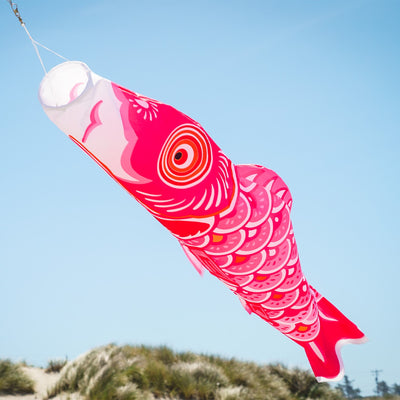 60-inch Pink Koi windsock with beautiful detail, displayed gracefully in an outdoor garden setting, adding color to the space.