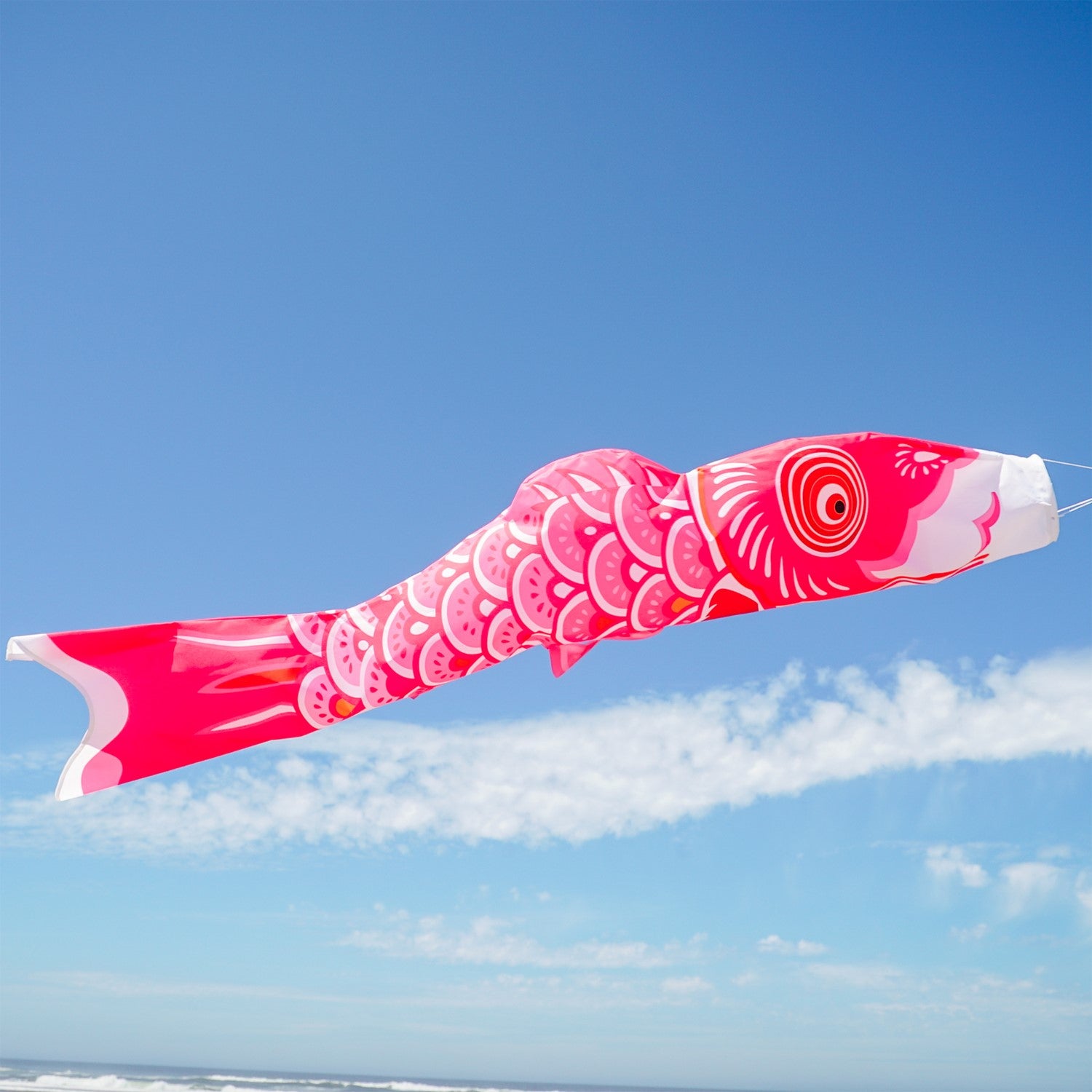 60-inch Pink Koi windsock with beautiful detail, displayed gracefully in an outdoor garden setting, adding color to the space.