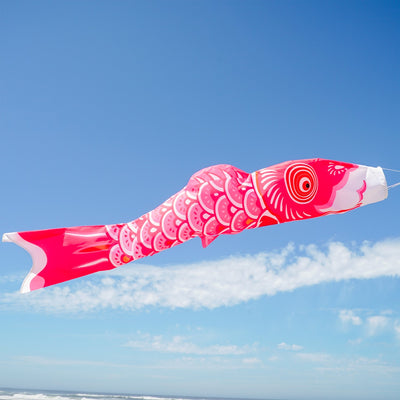 60-inch Pink Koi windsock with beautiful detail, displayed gracefully in an outdoor garden setting, adding color to the space.