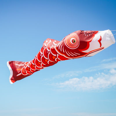 60-inch Red Koi windsock displaying vibrant colors and detailed design in a garden setting, perfect for outdoor decor.