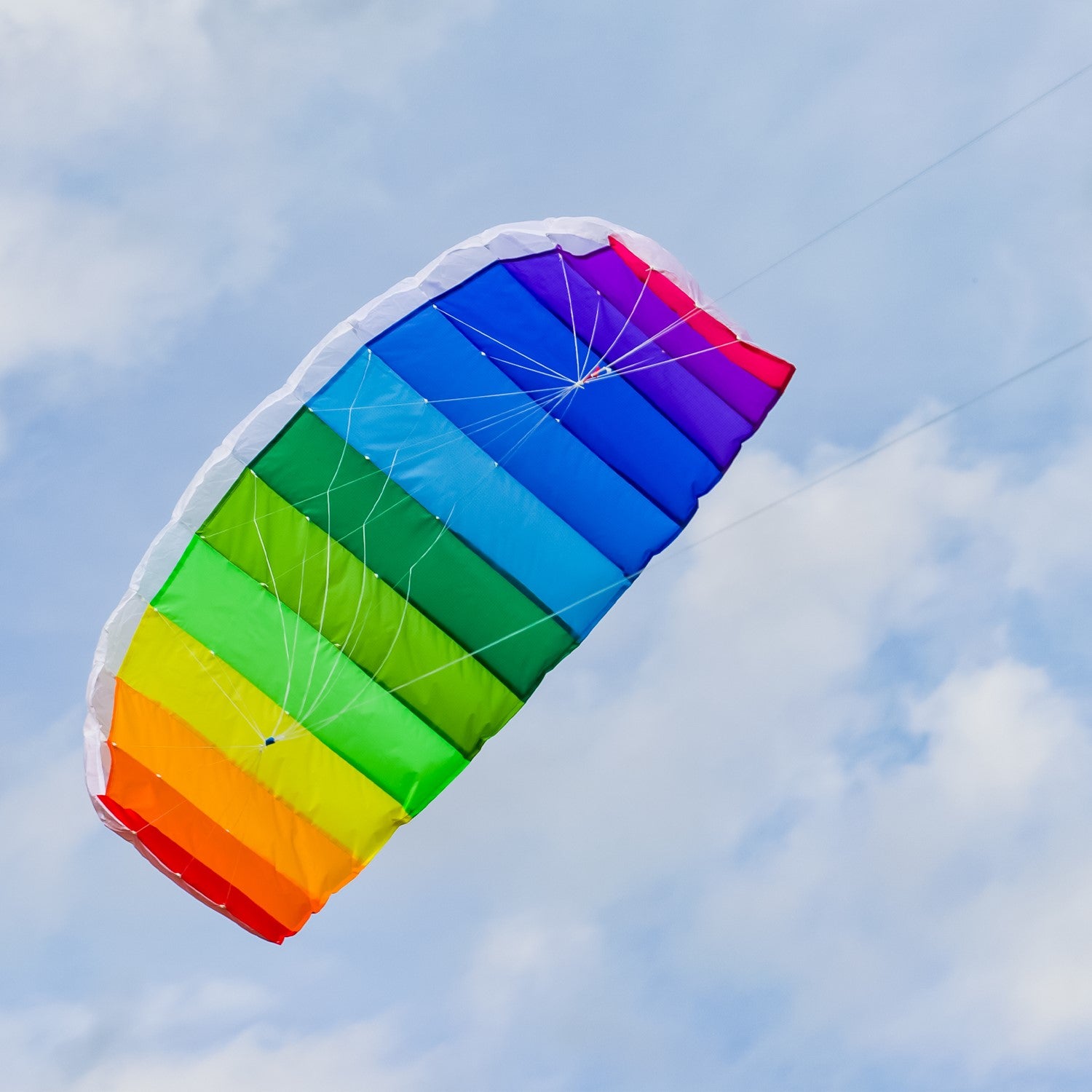 62-inch Sport Air Foil kite in rainbow colors soaring against a clear blue sky, demonstrating its aerodynamic design and double-line setup.