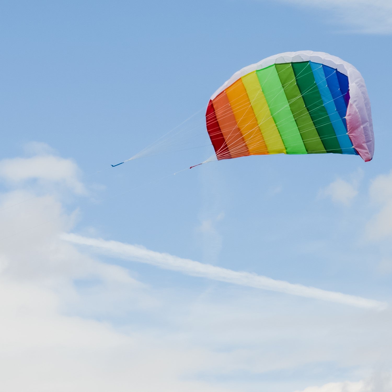 62-inch Sport Air Foil kite in rainbow colors soaring against a clear blue sky, demonstrating its aerodynamic design and double-line setup.