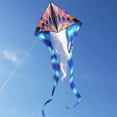 6.5 ft. Flo-Tail Delta Kite with gradient check design soaring high against a clear blue sky, featuring flowing 24-foot tails that catch the wind beautifully.