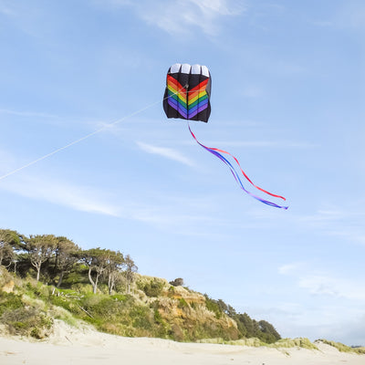 7.5 Rainbow Air Foil kite in flight, showcasing vibrant colors and aerodynamic design against a clear blue sky.