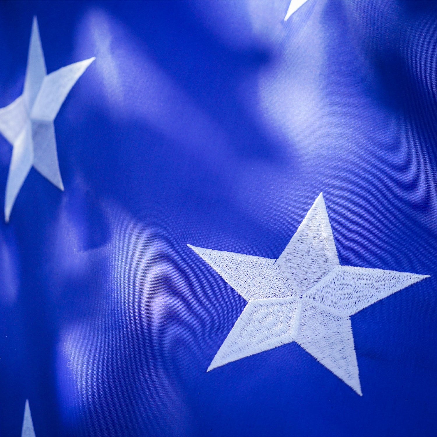 7-foot Embroidered Stars & Stripes Feather Banner featuring bold colors and embroidered stars displayed prominently outdoors at an event.