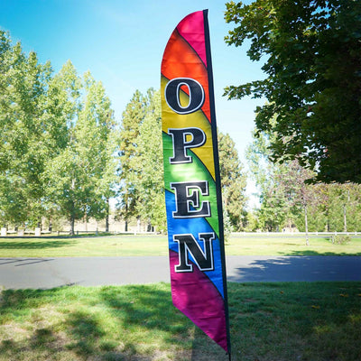 8' Heavy Duty Open Double-Sided Feather Banner displaying a colorful rainbow design outdoors, attracting attention to a storefront.
