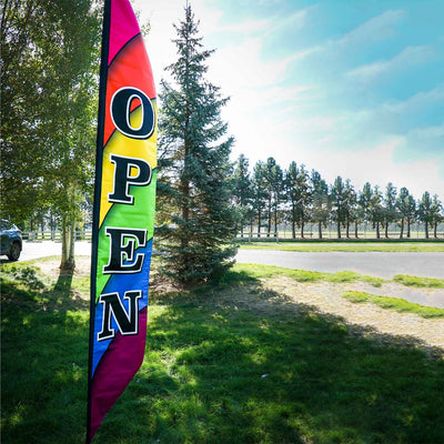 8' Heavy Duty Open Double-Sided Feather Banner displaying a colorful rainbow design outdoors, attracting attention to a storefront.