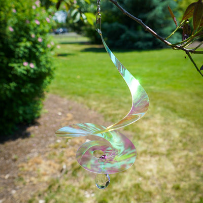 8-inch iridescent tear drop curlie with crystal spinner, shimmering in sunlight, hanging gracefully in an outdoor setting.