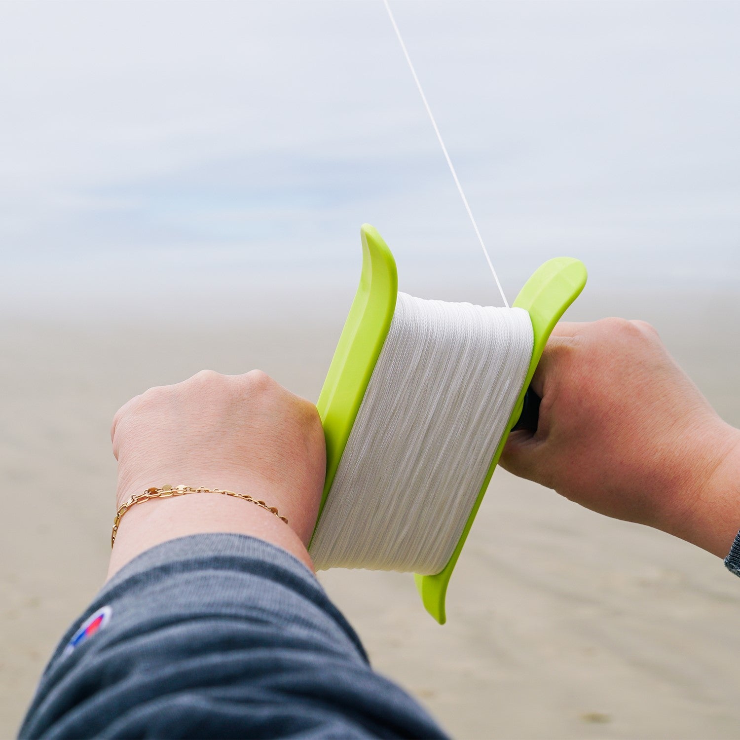 Green 80lb x 500' Braided Breezy WinderTM, featuring strong braided kite line, designed for effortless kite management and outdoor fun.