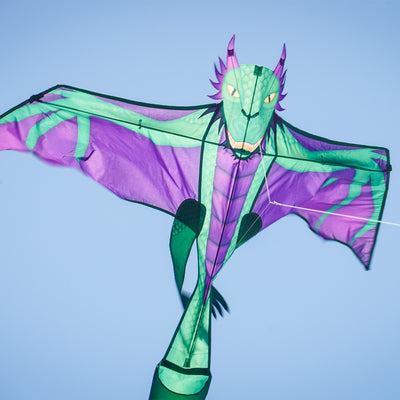 90" dragon kite featuring a vibrant dragon design soaring through the sky, complete with a long inflatable tail for stability and easy handling.