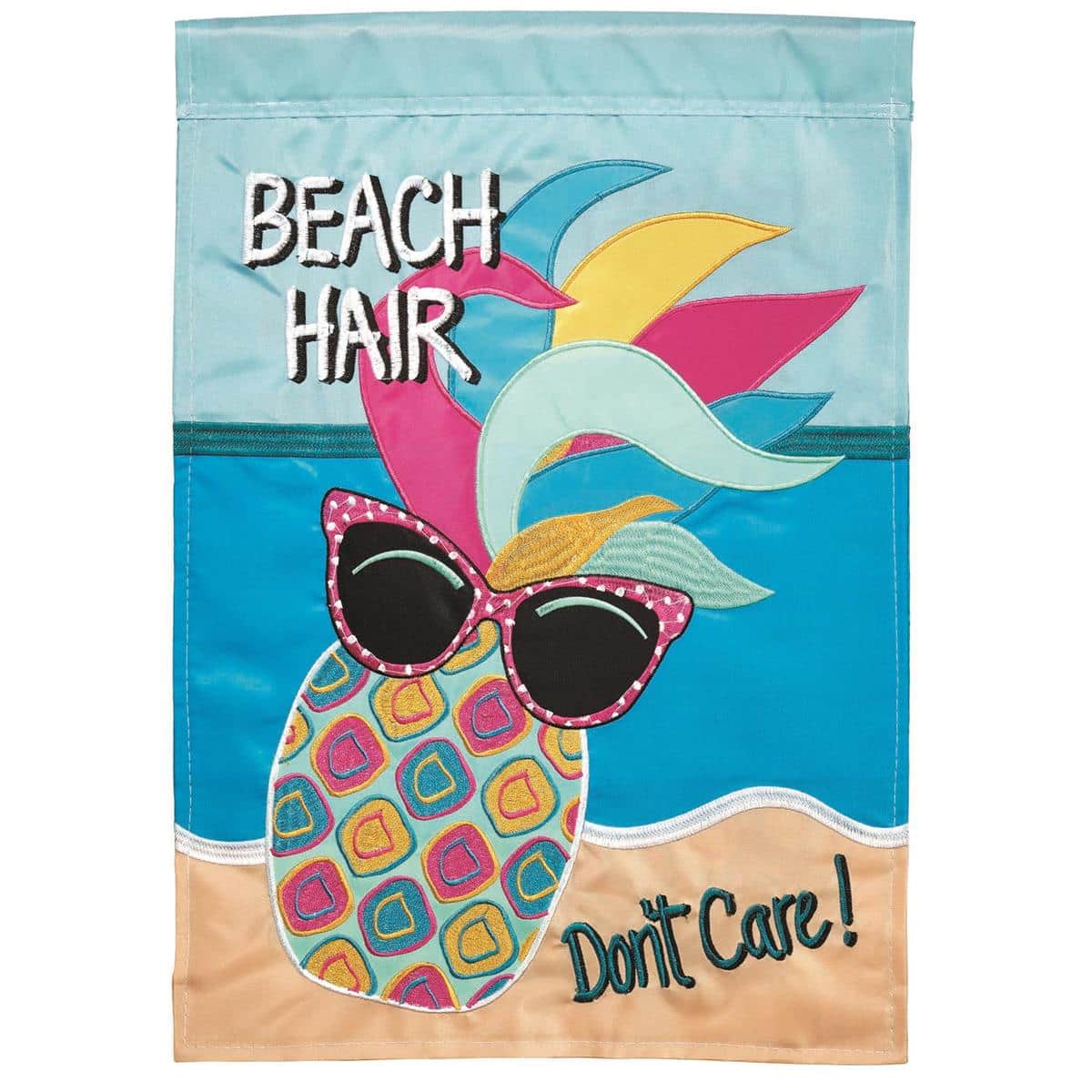 Tropical illustration of a pineapple with beach hair and sunglasses on a 29 by 42 inch double applique banner flag displayed hanging from a garden pole in a sunny yard.