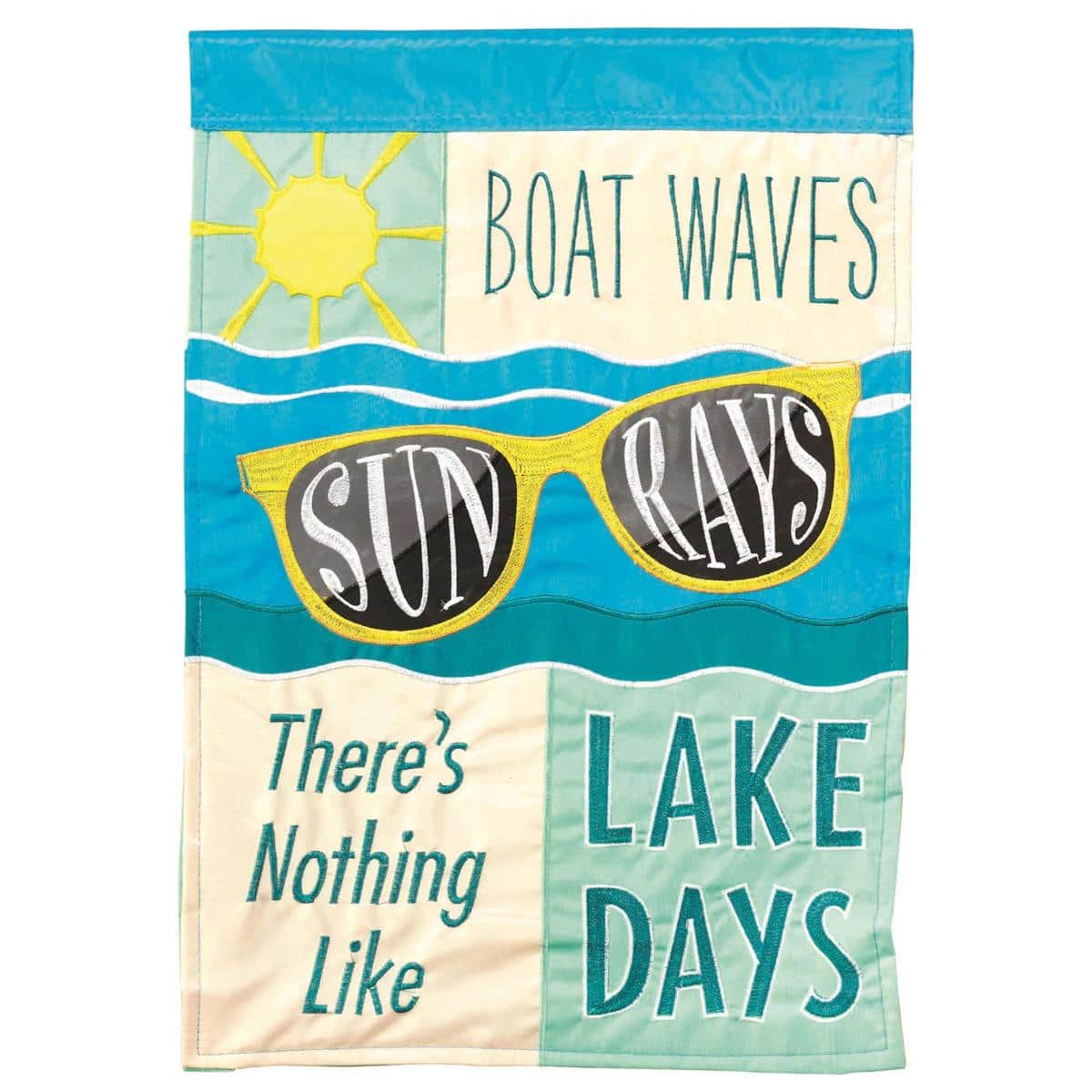 13x18 boat garden flag showing a stylized boat silhouette riding waves under radiant sun rays in a double applique construction, photographed mounted on a short garden pole in front of a lakeside porch with natural wood tones and greenery.