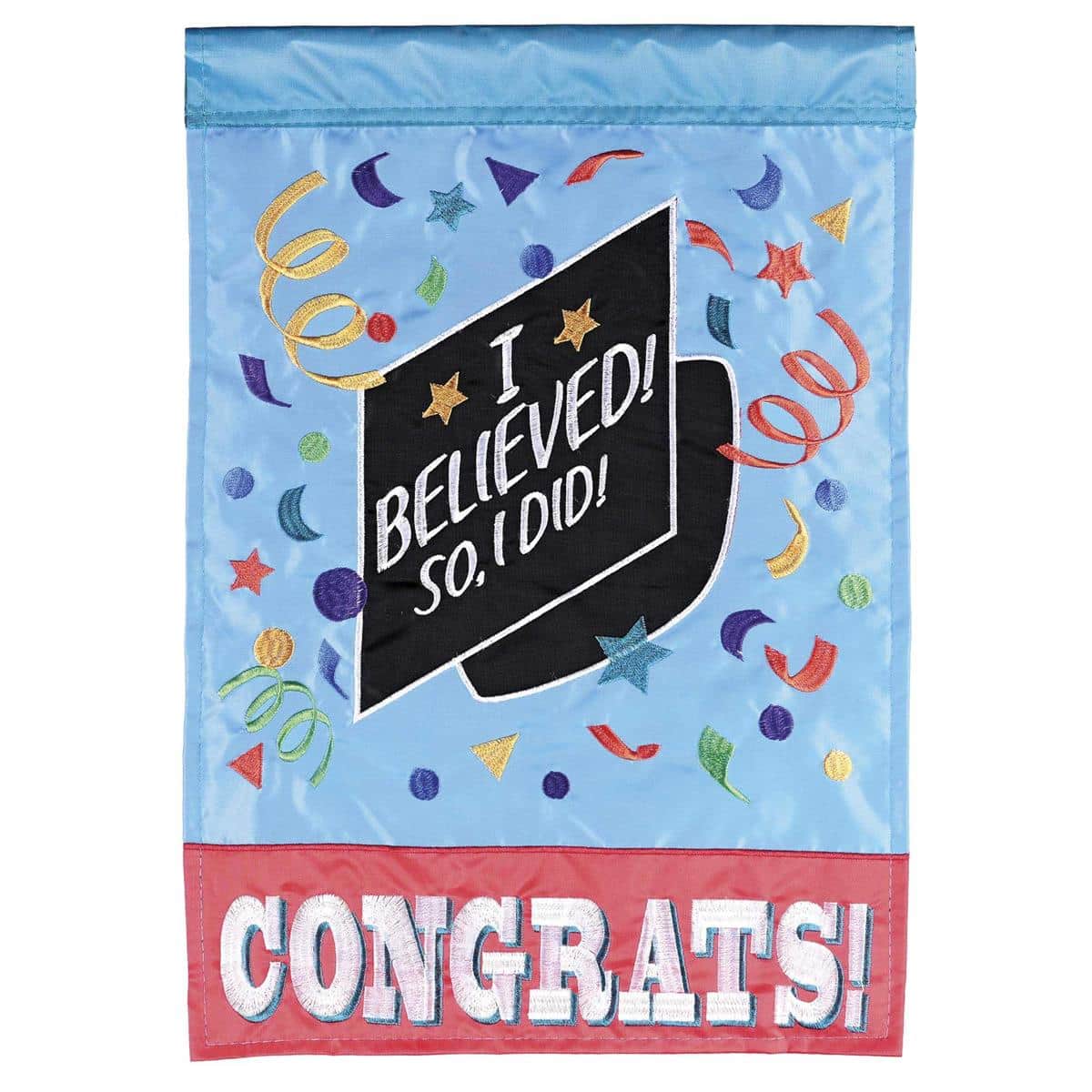 Photo of a Congrats Grad Garden Flag 13x18 displayed on a metal garden flag stand in a front yard, showing a double applique design with graduation cap, diploma, laurel accents, and celebratory confetti on a contrasting background.