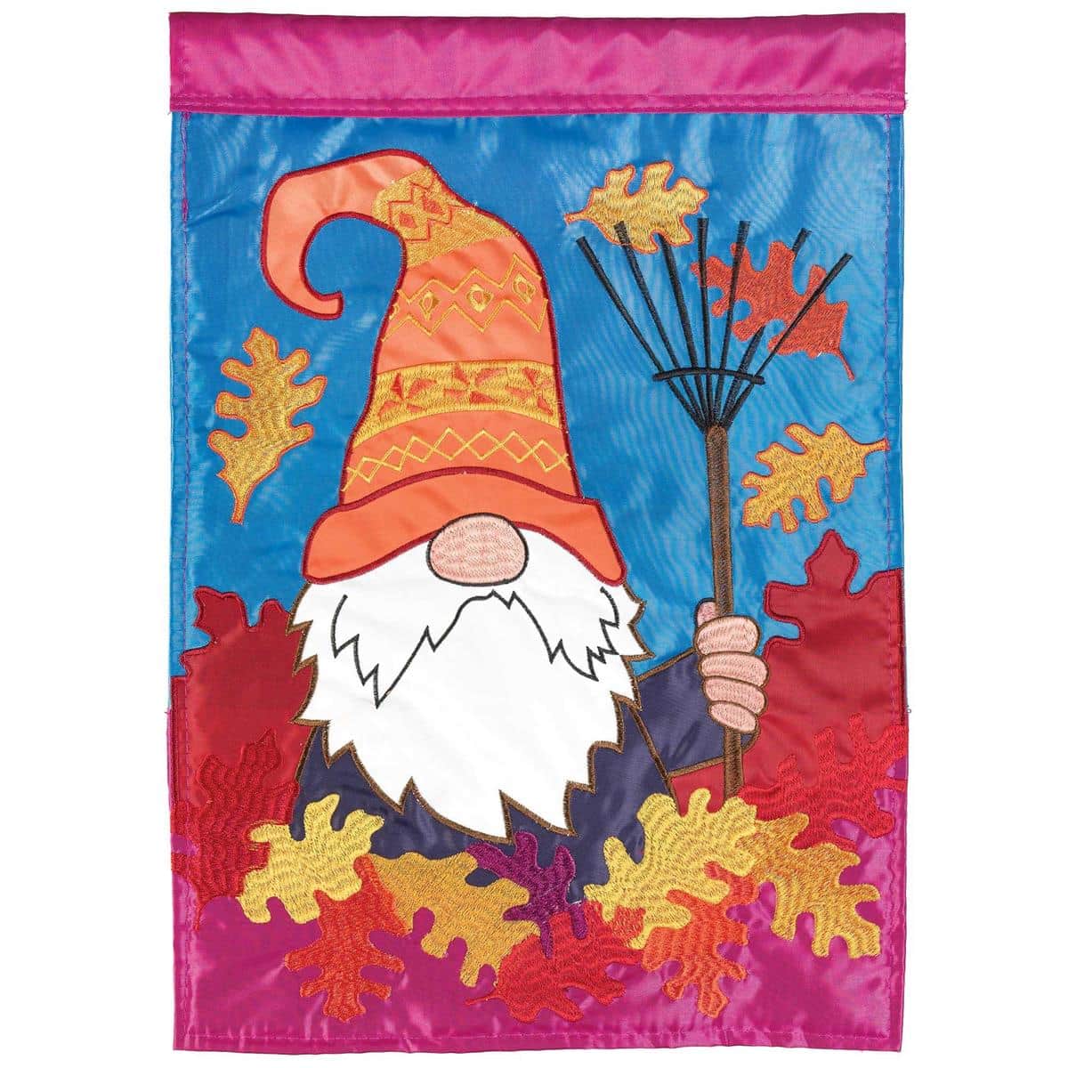 13x18 fall garden flag showing a smiling gnome surrounded by layered appliqued autumn leaves in warm oranges and browns, hanging on a metal yard flag pole in a porch setting.