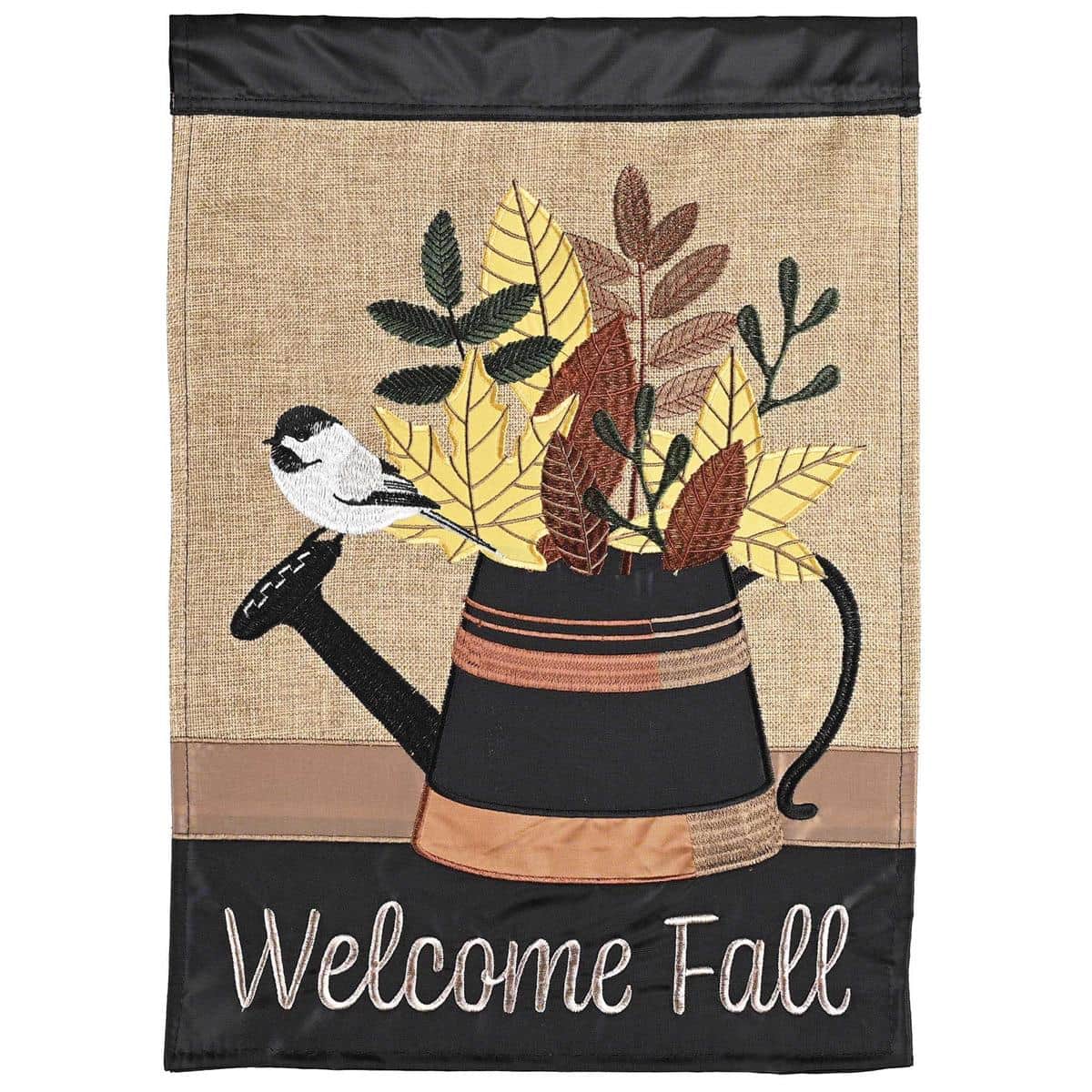 Garden flag image showing a striped watering can motif filled with autumn leaves in warm orange, red, and gold tones, double applique layers adding textured depth and stitched detailing for outdoor display.
