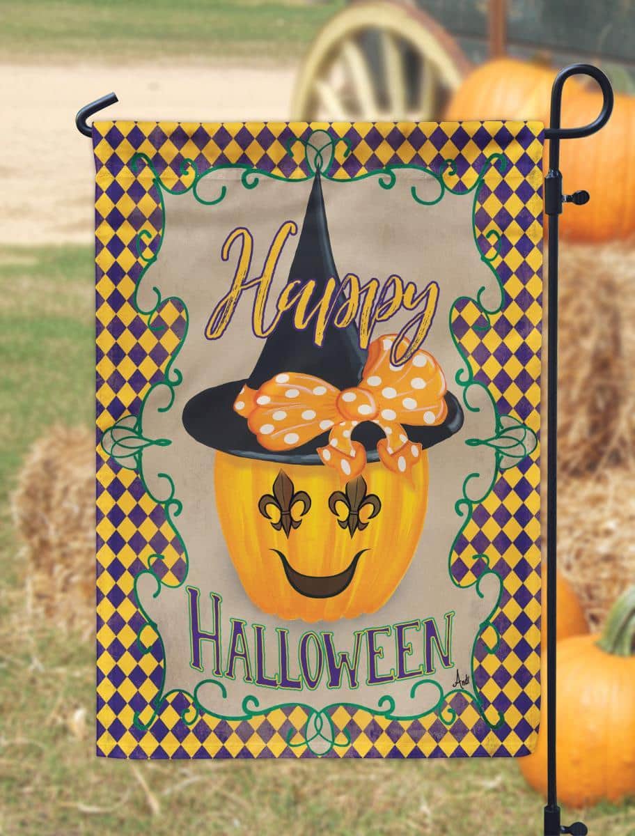 Close-up of 13x18 Halloween garden flag with ornate fleur-de-lis symbol, bold black and orange print, weather-resistant polyester, and top pole sleeve outdoors