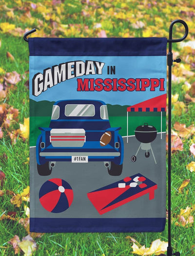 13x18 Gameday Mississippi garden flag in navy and red with double applique design shown mounted on a metal yard pole in a grassy front yard setting.