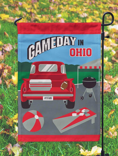 Gameday Ohio 13x18 red and grey double applique garden flag hanging on a small garden pole in a front yard, showing bold team colors, layered applique texture, and neat hemmed edges.