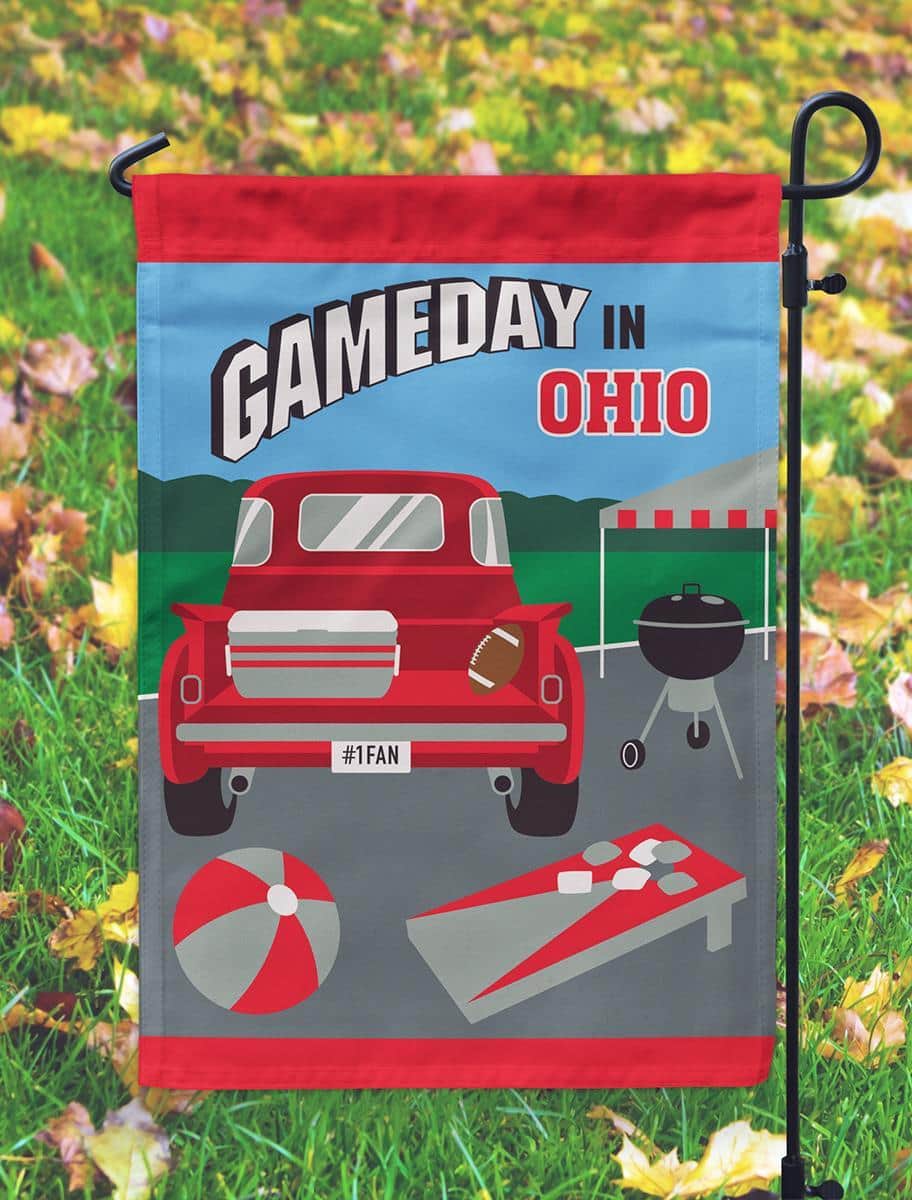 Gameday Ohio 13x18 red and grey double applique garden flag hanging on a small garden pole in a front yard, showing bold team colors, layered applique texture, and neat hemmed edges.