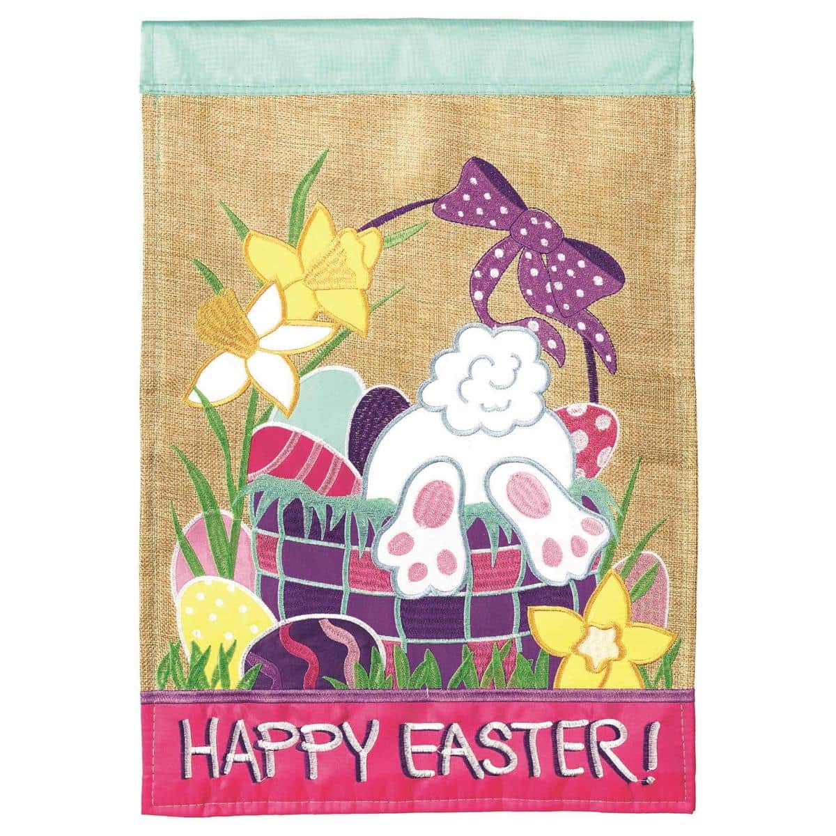 Close-up of a 13x18 Happy Easter burlap garden flag with double applique letters, pastel eggs and floral accents on textured burlap hanging from a metal garden stake in a grassy yard.