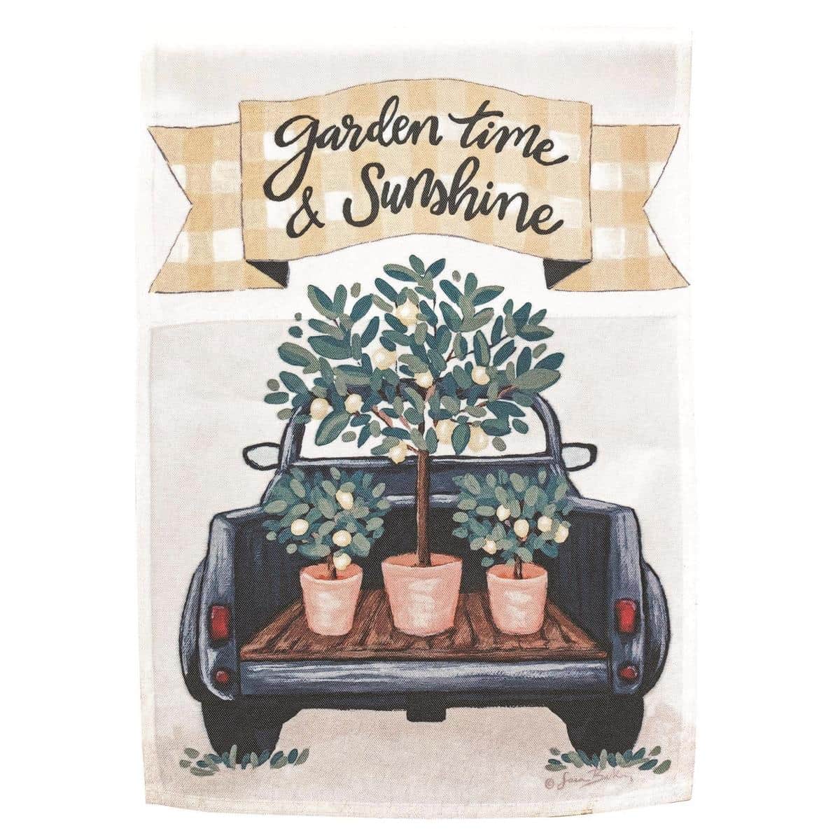 Lemon Truck Garden Time 13x18 printed garden flag showing a vintage yellow pickup truck filled with lemons and spring flowers on a white background, hanging from a garden flag pole near potted plants.