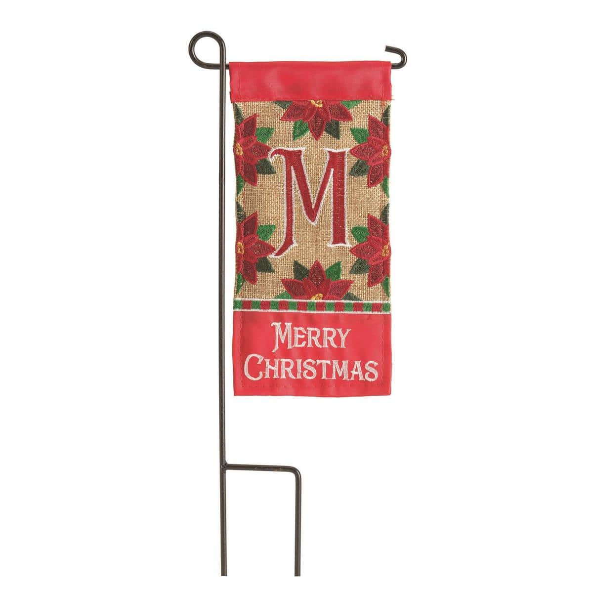 4x8 inch mini Christmas monogram flag with letter M in a wreath, red and green background, holly accents, shown mounted on a small garden planter flag stand