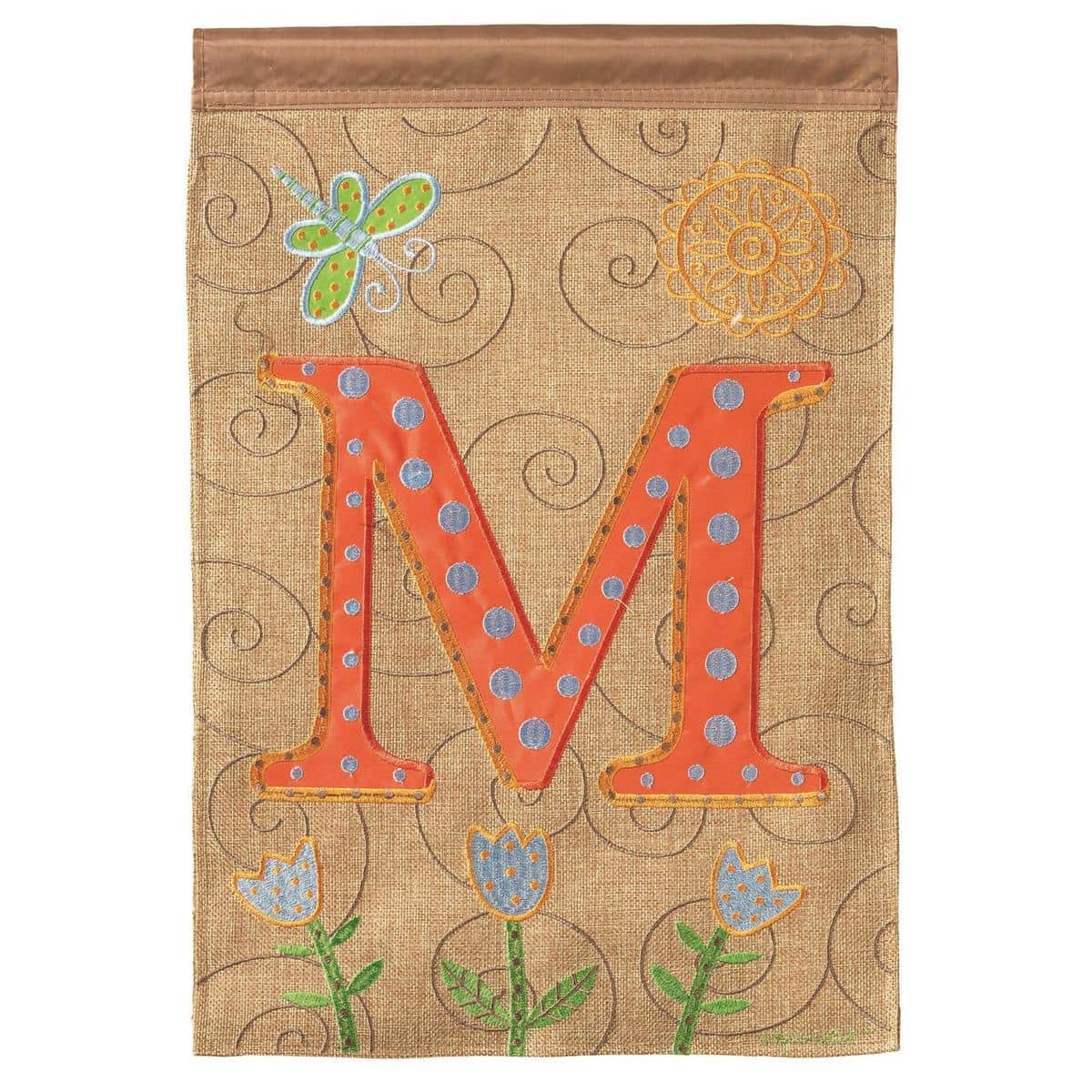 Close-up of Monogram letter M on a 13x18 double applique garden flag showing layered fabric textures, stitched edges, and bold initial design mounted on a porch flag pole.