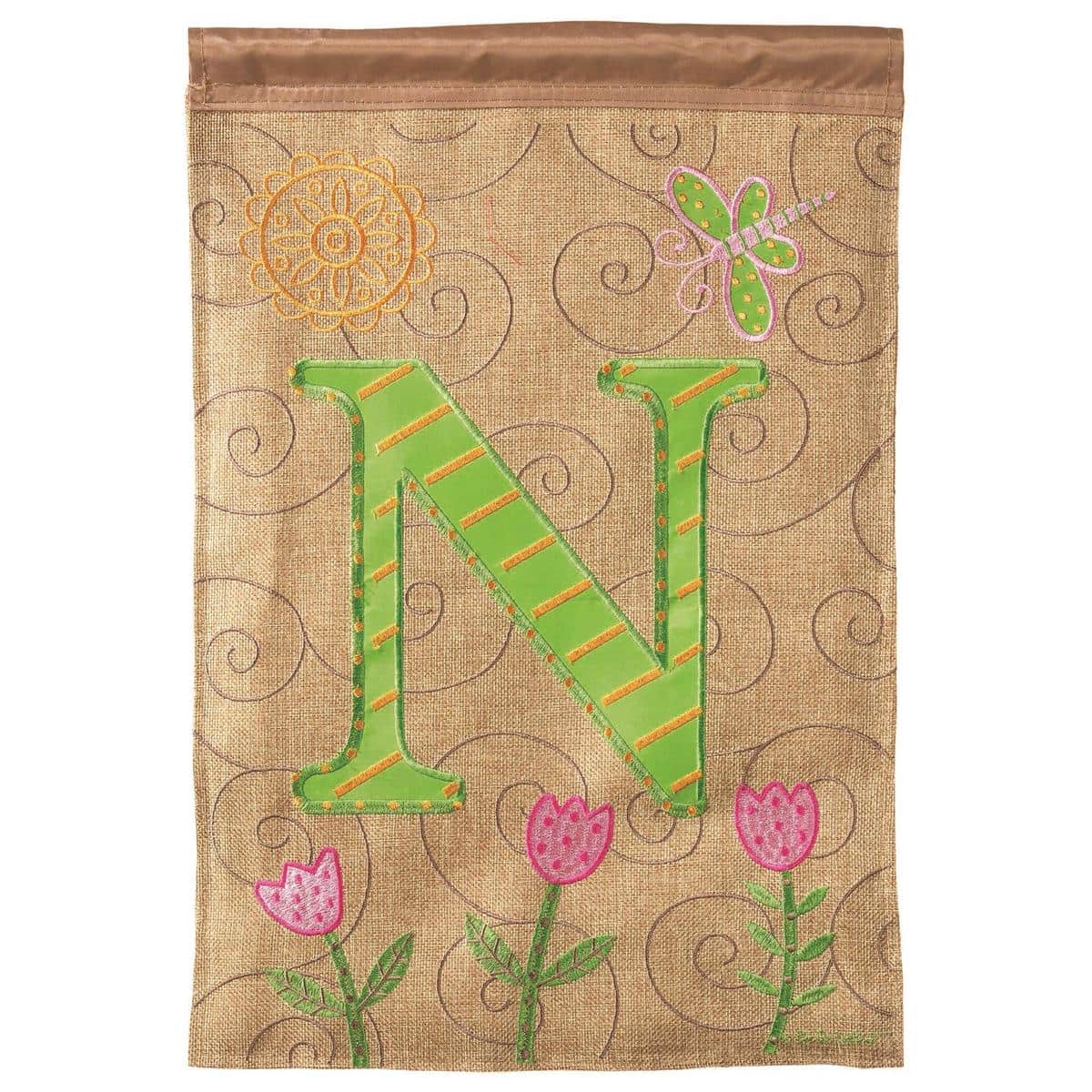 Close-up of a personalized 13x18 garden flag featuring a stitched capital N monogram, double applique detail, two sided design, and a top sleeve for a stand.