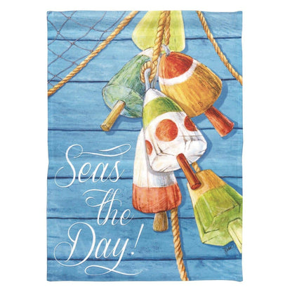 Seas The Day banner flag hanging on a front porch with navy and sand tones, showing playful 'Seas The Day' text and coastal wave and shell motifs in a printed coastal design.