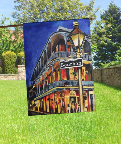 30x44 printed Street Car Bourbon Mardi Gras banner flag hanging from a porch pole, showing Festive Bourbon Street signage in purple green and gold on durable printed fabric with visible pole sleeve.
