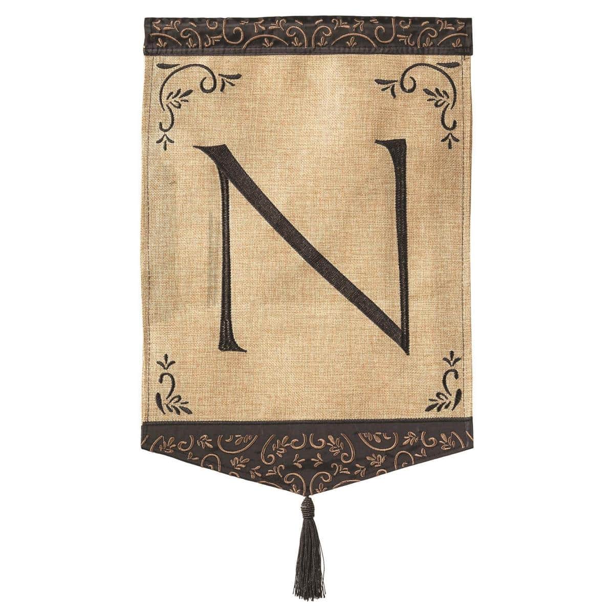 Tassel Burlap Monogram N double applique 13x18 garden flag with stitched letter, reinforced sleeve, and tassel accent, displayed on a standard garden stand outdoors.