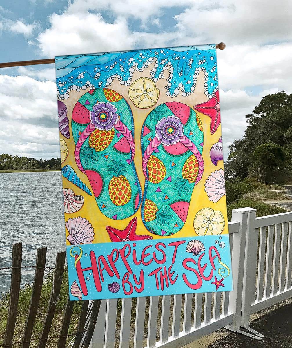 Tropical Paradise 30x44 banner flag, coastal printed design with palm-inspired artwork and ocean hues, displayed outdoors on a house pole by a front porch.