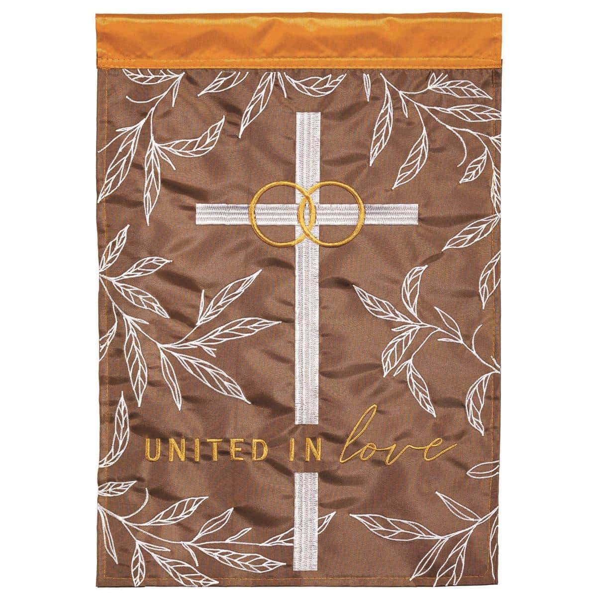 White and blush "United In Love" 13x18 garden flag with double applique hearts and script displayed on a metal garden pole in a garden setting.